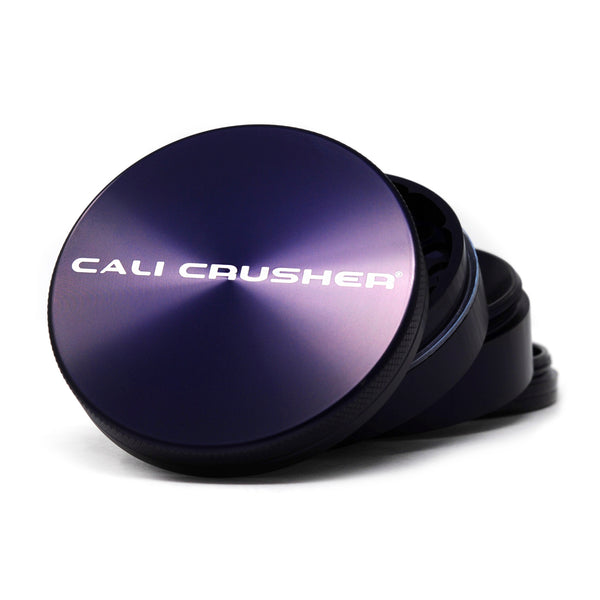Purple Cali Crusher O.G. Hard Top 2.5 inch 4-piece metal grinder on its side with lid off, logo on top